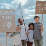kids holding cardboards that says save the earth